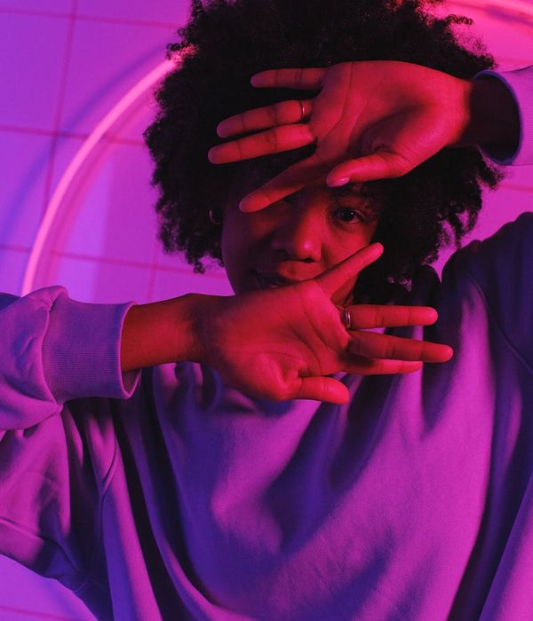 Woman in activewear performing a dynamic cardio move in a modern studio.